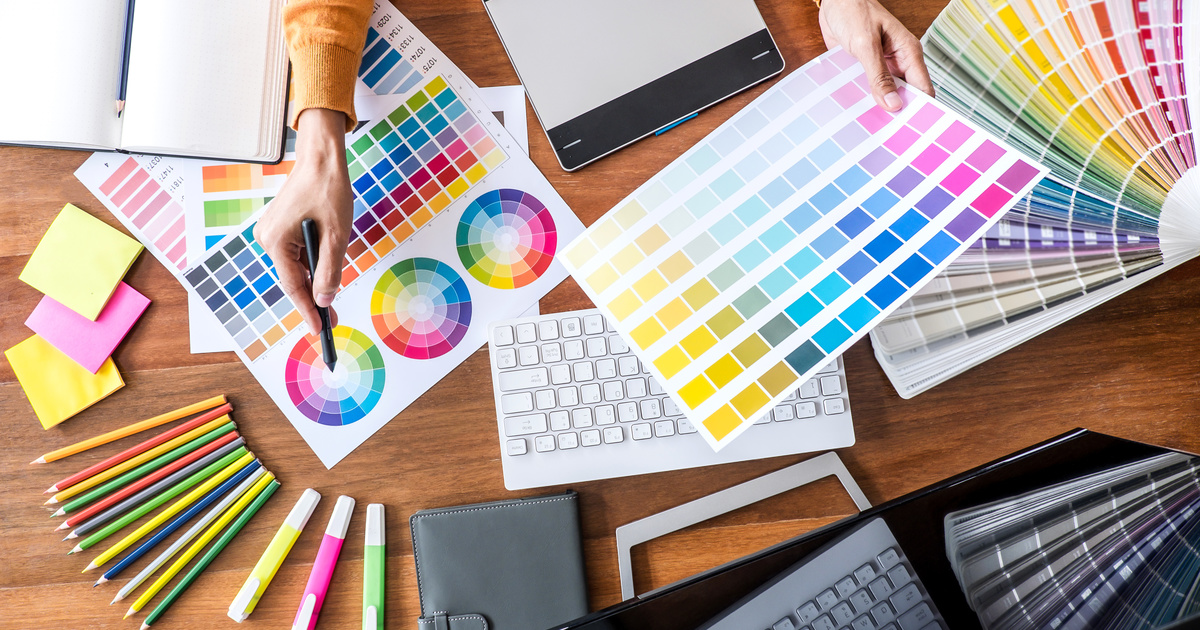 Designer reviewing a brand's visual identity across several screens