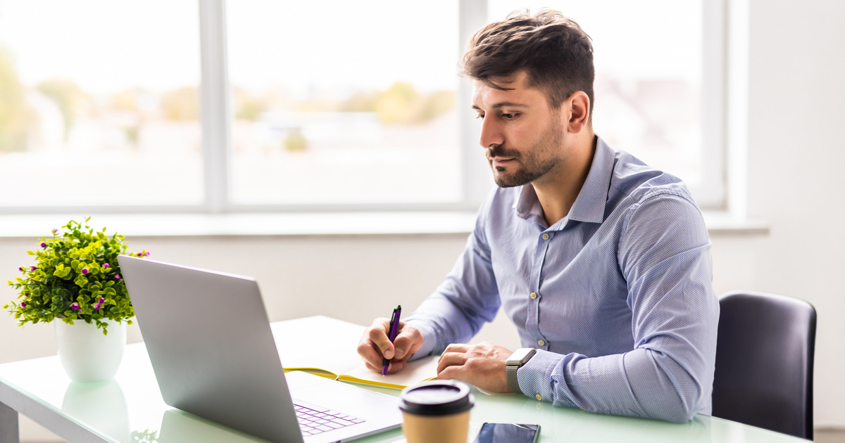 Empresario tomando notas sobre sus clientes en su escritorio